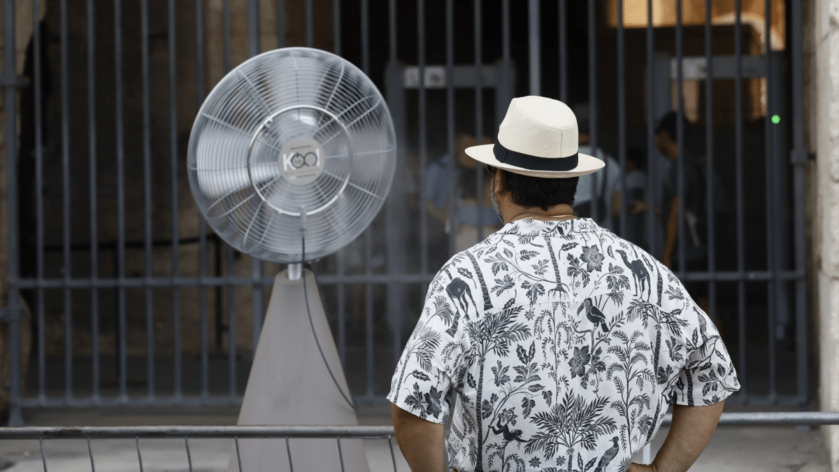 Un hombre delante de un ventilador en Italia, que es uno de los países más usan el aire acondicionado en verano
