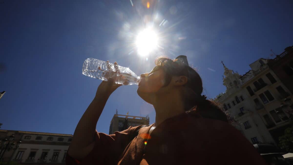 Una mujer se refresca bebiendo agua en el centro de Córdoba donde se ha dado aviso naranja por altas temperaturas.