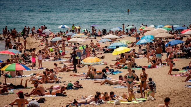 Turistas playa Barcelona Turistas y locales descansan tranquilos en una playa de Barcelona.