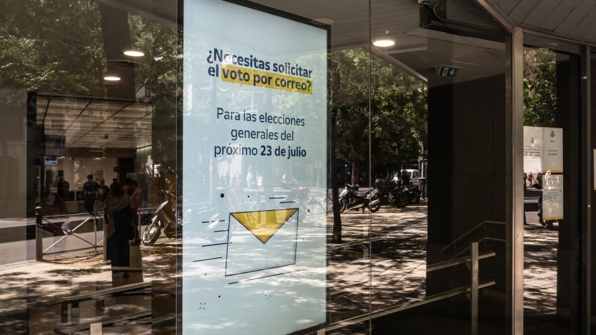 Un cartel informa sobre el voto por correo en una oficina de la empresa pública de Madrid.