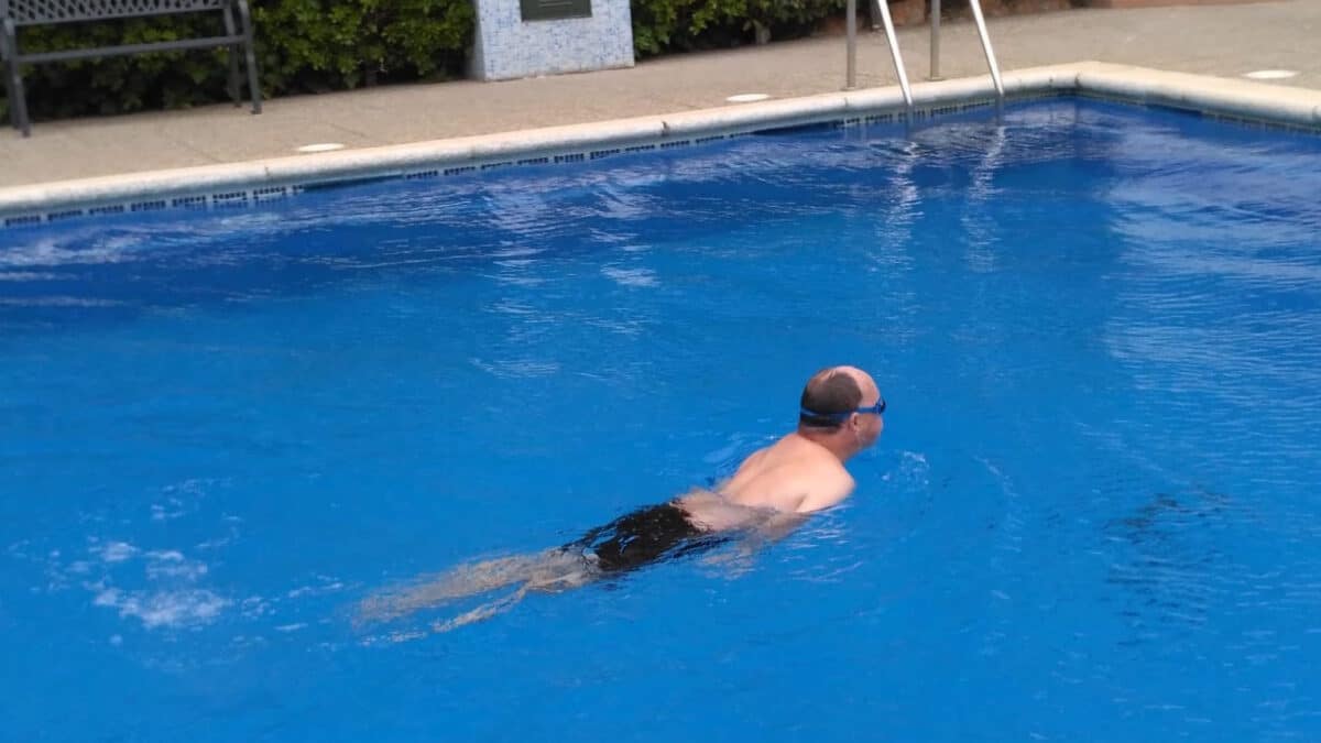 Carlos nada en la piscina