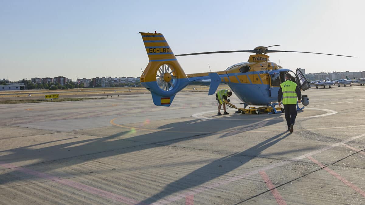 Dos operarios chequean uno de los helicópteros Pegasus de la DGT minutos antes de despegar para controlar el tráfico por las carreteras