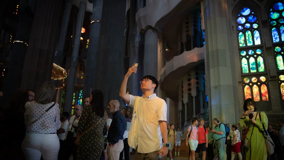 Un hombre toma una fotografía del interior de la catedral de la Sagrada Familia.