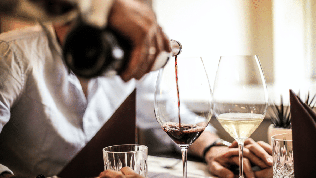 Un camarero sirviendo unas copas de vino, considerados los mejores vinos de España, según los Premios Alimentos de 2023