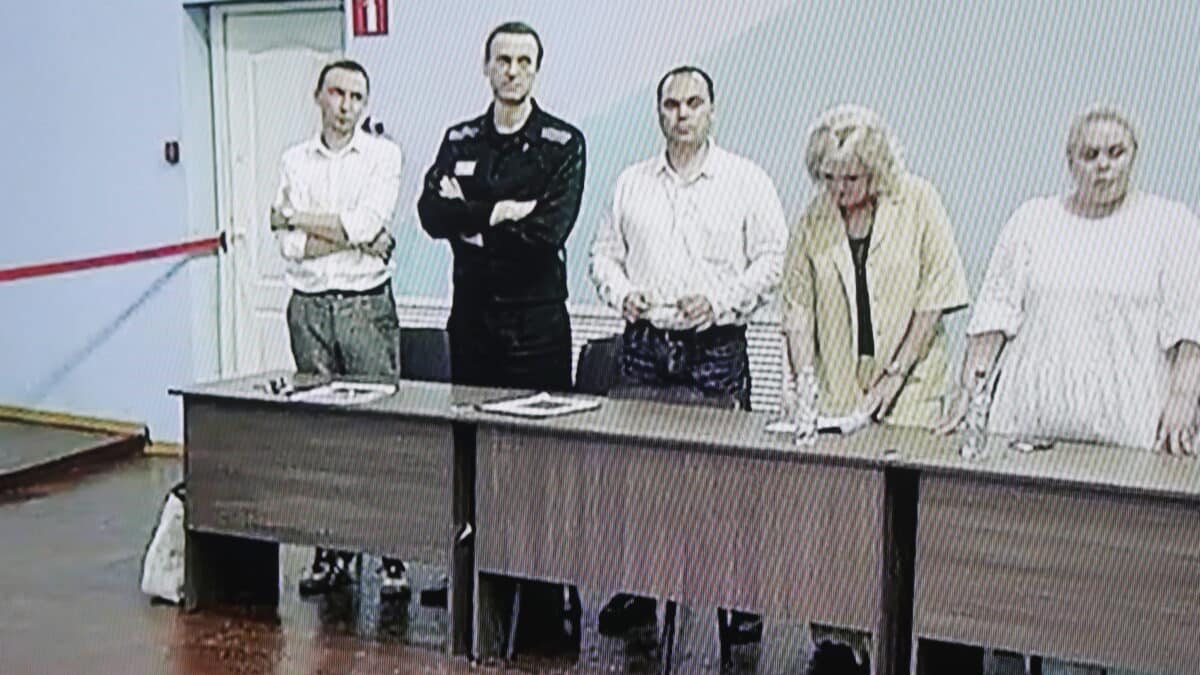 La figura de la oposición rusa Alexei Navalny (2-L) se ve en una pantalla durante una audiencia de veredicto fuera del sitio del tribunal de la ciudad de Moscú en el caso de la figura de la oposición rusa Alexei Navalny