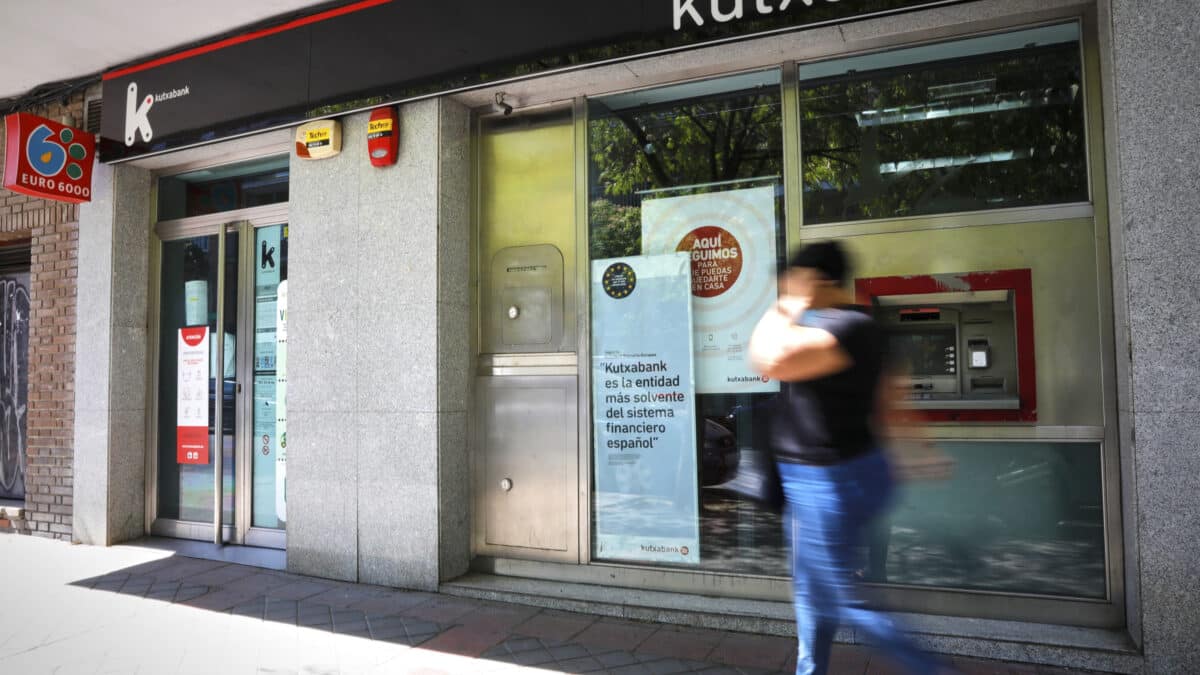 Una persona pasa por el exterior de la sucursal del banco Kutxabank en la Calle de la Oca de Madrid