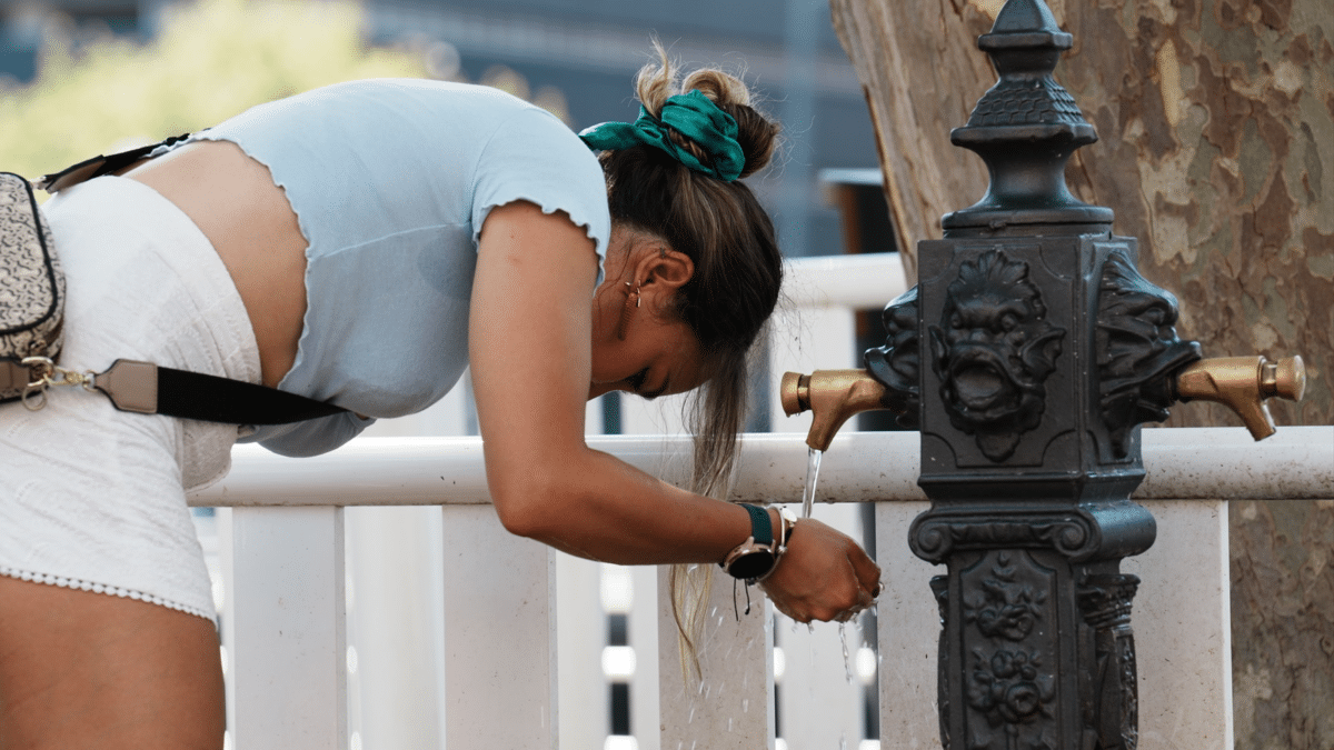 Una mujer bebe de una fuente de agua, donde prosperan las bacterias de Legionella