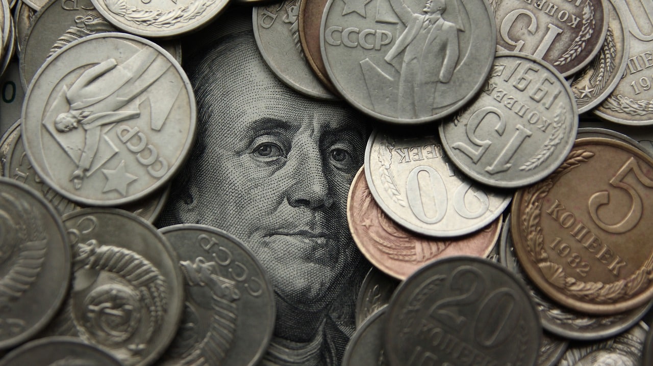Monedas de rublo sobre un billete de dólar.