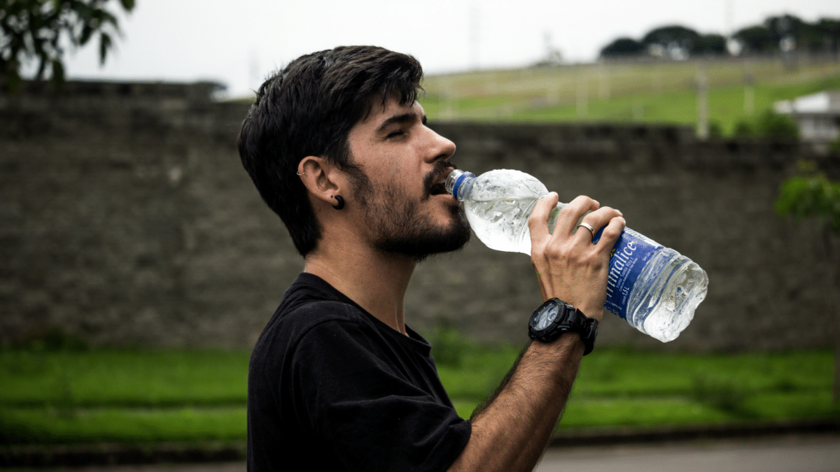 Una persona bebiendo de una botella, preguntando si se puede morir por beber demasiada agua