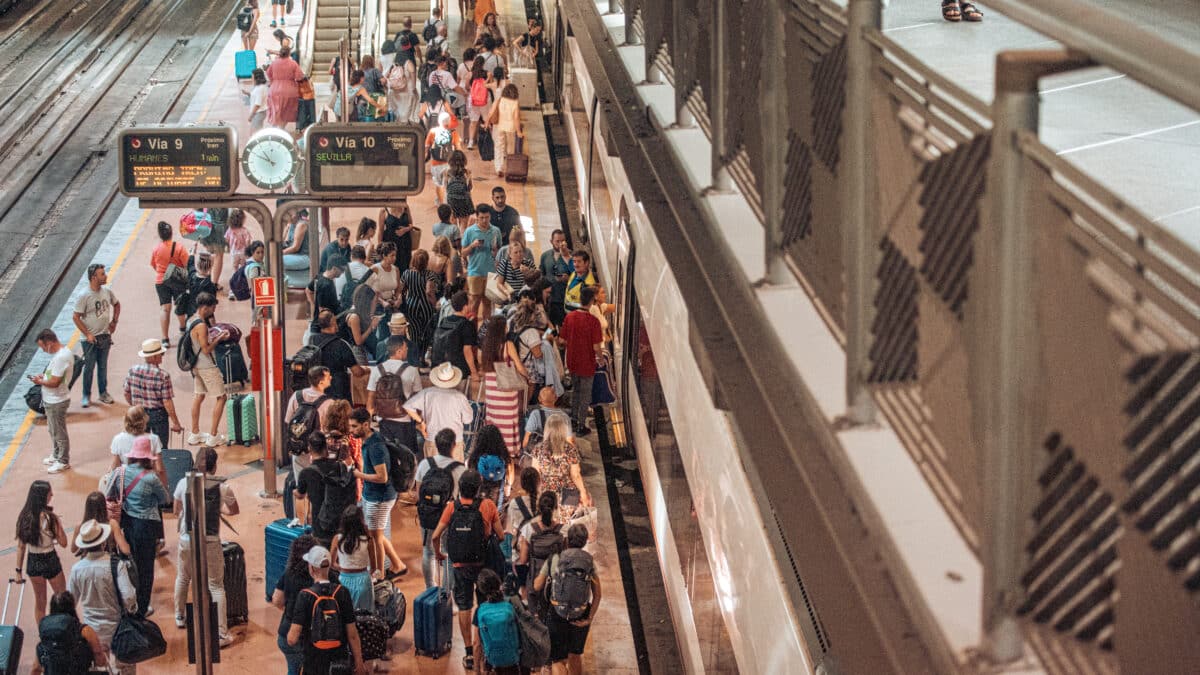 Varias personas en el andén de un tren de cercanías en la estación Almudena Grandes-Atocha Cercanías