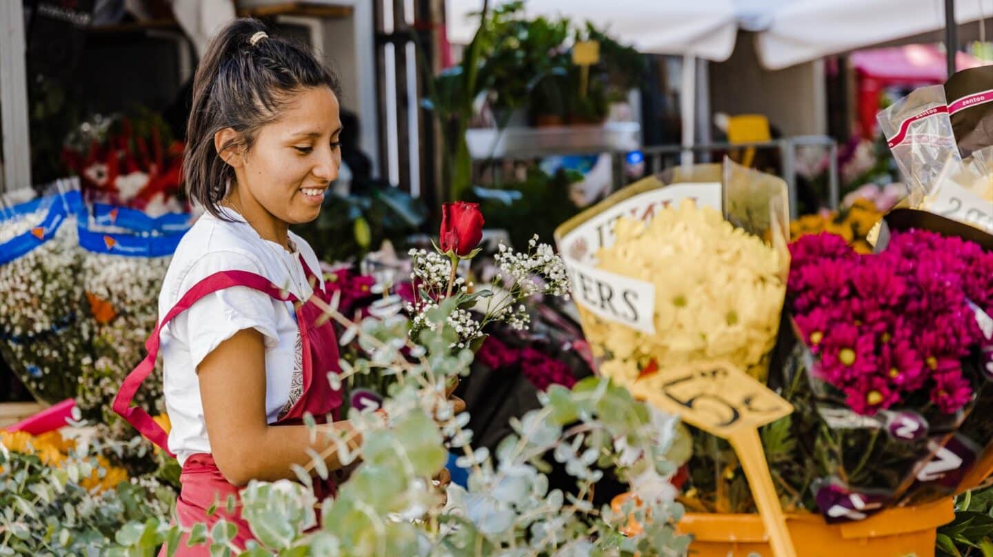 Una vendedora prepara ramos de flores en un puesto de Tirso de Molina, en Madrid.