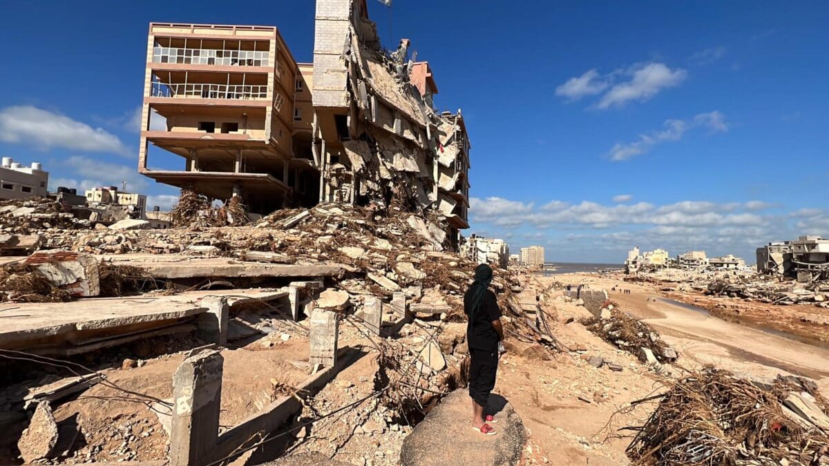 Un hombre frente a algunos de los edificios derrumbados en Derna (Libia)