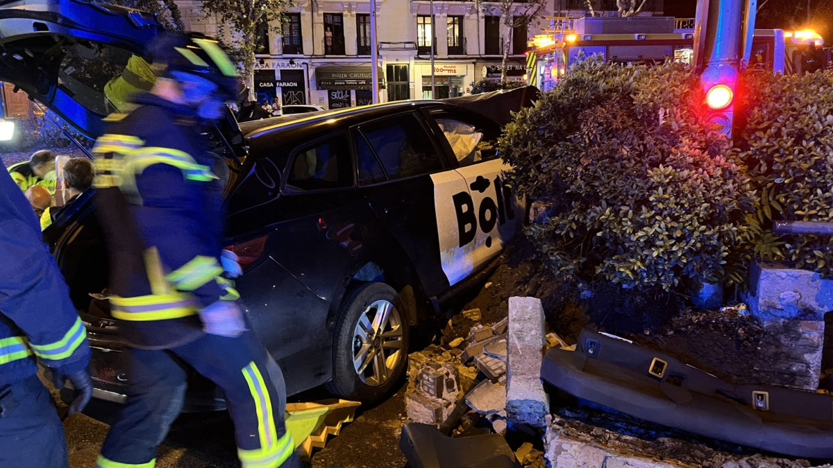 Bomberos junto al coche accidentado en Atocha (Madrid).