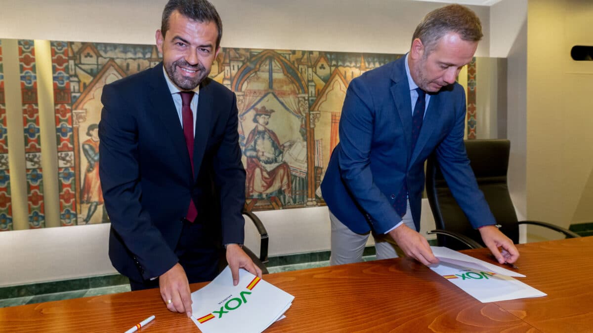 Los portavoces de Vox Rubén Martínez (i) y del PP Joaquín Segado (d) en el parlamento murciano se dan la mano tras la firma del acuerdo de gobierno este martes en la Asamblea Regional en Cartagena.