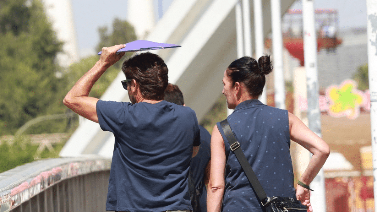 Un hombre usa una carpeta para protegerse de las altas temperaturas que se esperan este finde con la llegada del “veroño” y máximas de hasta 37ºC