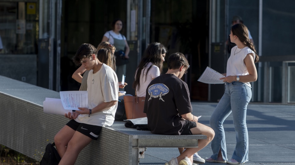 Un grupo de estudiantes espera a las puertas de la universidad.