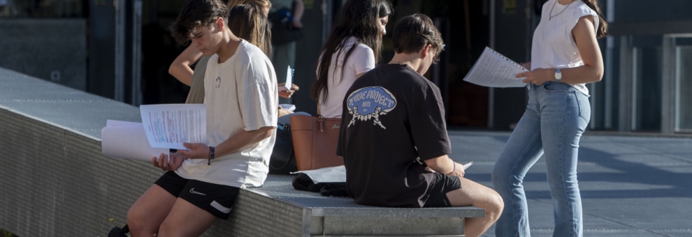 Un grupo de estudiantes espera a las puertas de la universidad.