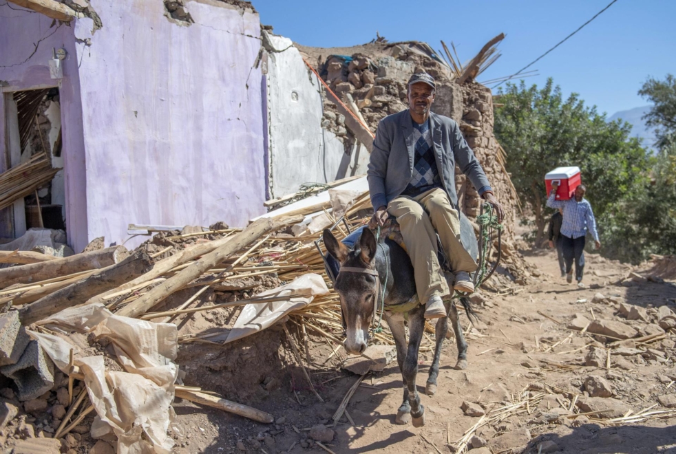 Un hombre a lomos de un burro pasa por los restos de viviendas en Tinmel (Marruecos).