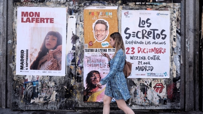Joven bono cultural Una joven pasa delante de varios carteles de conciertos en Madrid.