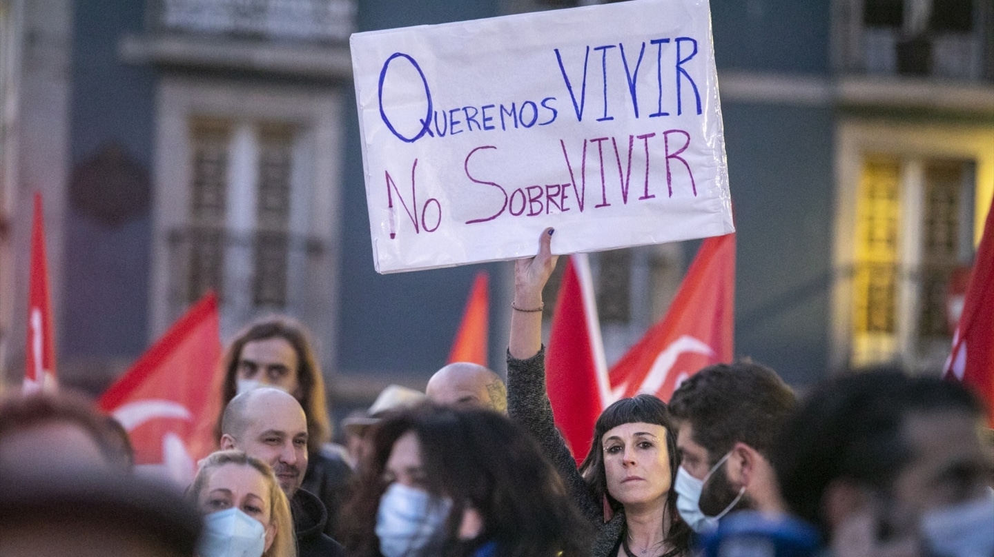 Una mujer sostiene una pancarta durante una concentración contra en Avilés, Asturias.