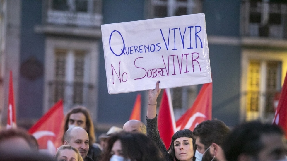 Una mujer sostiene una pancarta durante una concentración contra en Avilés, Asturias.