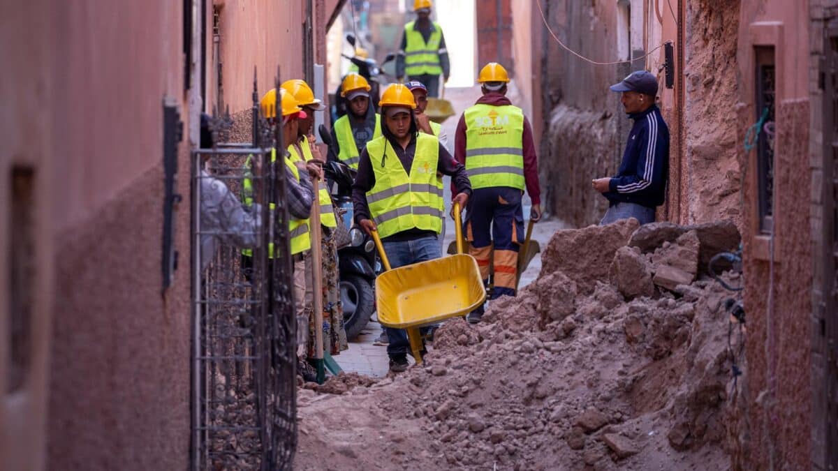 Varios hombres limpian escombros de un edificio