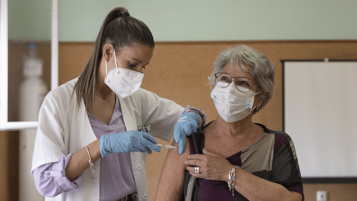 Una enfermera vacuna a una mujer, después de que se adelante la campaña de vacunación conjunta de gripe y covid a final de septiembre de 2023