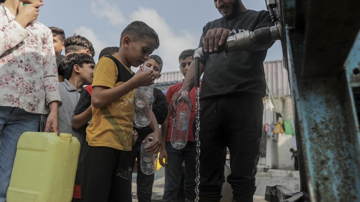 Residente del campo de refugiados de Khan Yunis hacen cola para recibir agua.