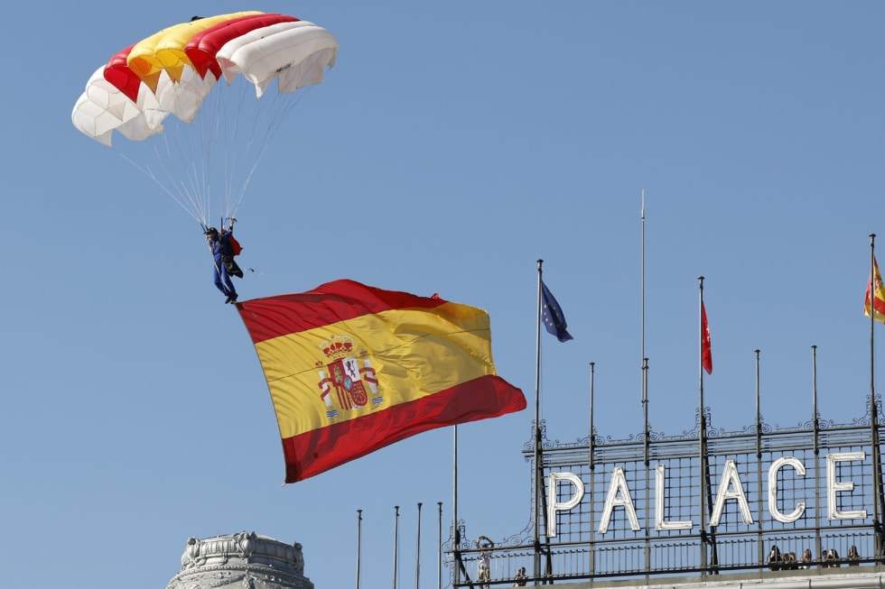 La cabo Mari Carmen Gómez Hurtado desciende la bandera al inicio del desfile del Día de la Fiesta Nacional en Madrid