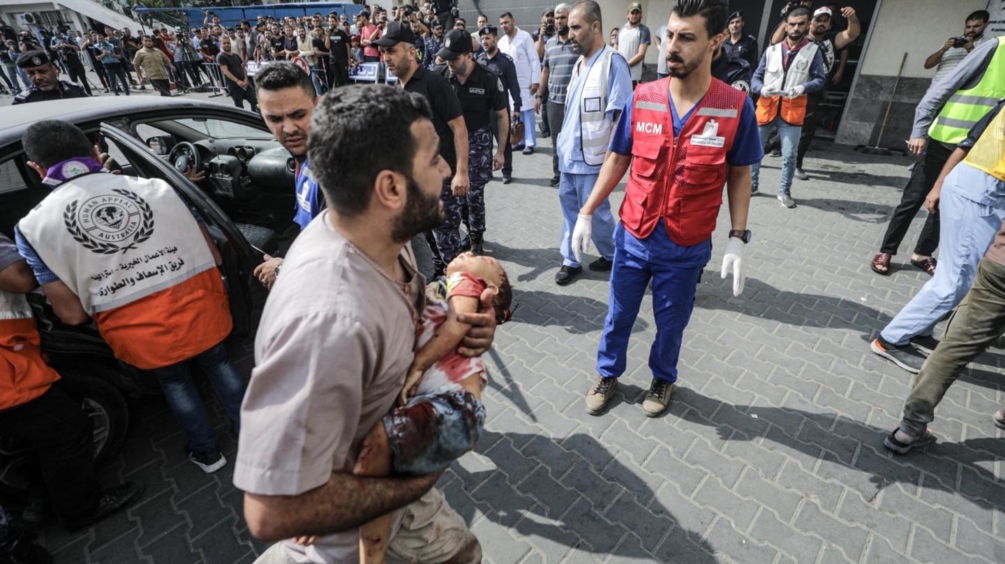 Un palestino transporta a un niño al hospital de Al Shifa tras un ataque aéreo israelí.