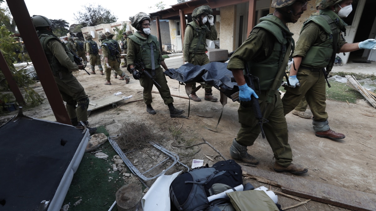 Soldados israelíes recuperan cadáveres tras el ataque de Hamás a un kibbutz.