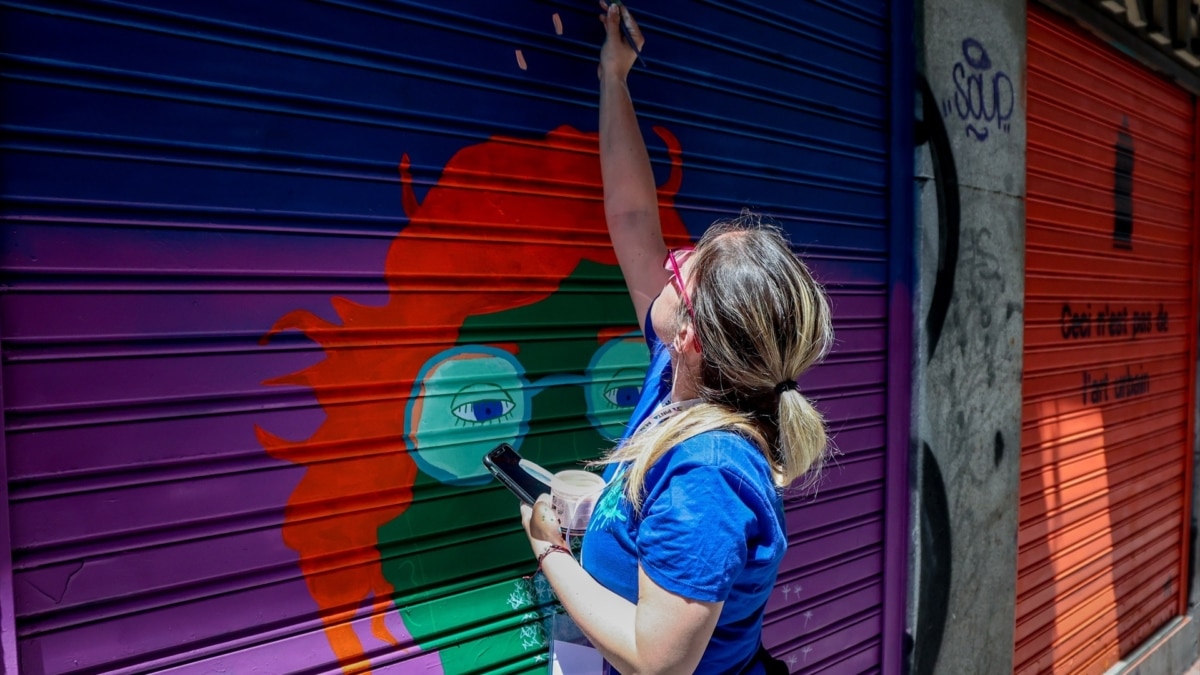 Una artista pinta un local de Malasaña, en Madrid.