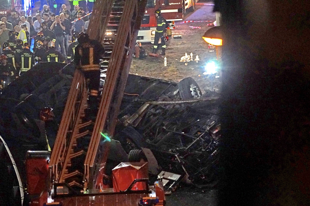 Personal de rescate trabaja en el lugar donde un autobús de pasajeros se estrelló desde un tramo elevado en Mestre, cerca de Venecia