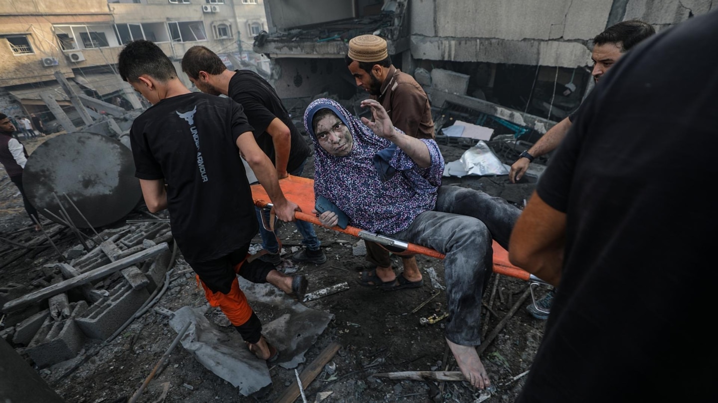 Una mujer es auxiliado en un edificio golpeado por un ataque aéreo israelí en la ciudad de Gaza.