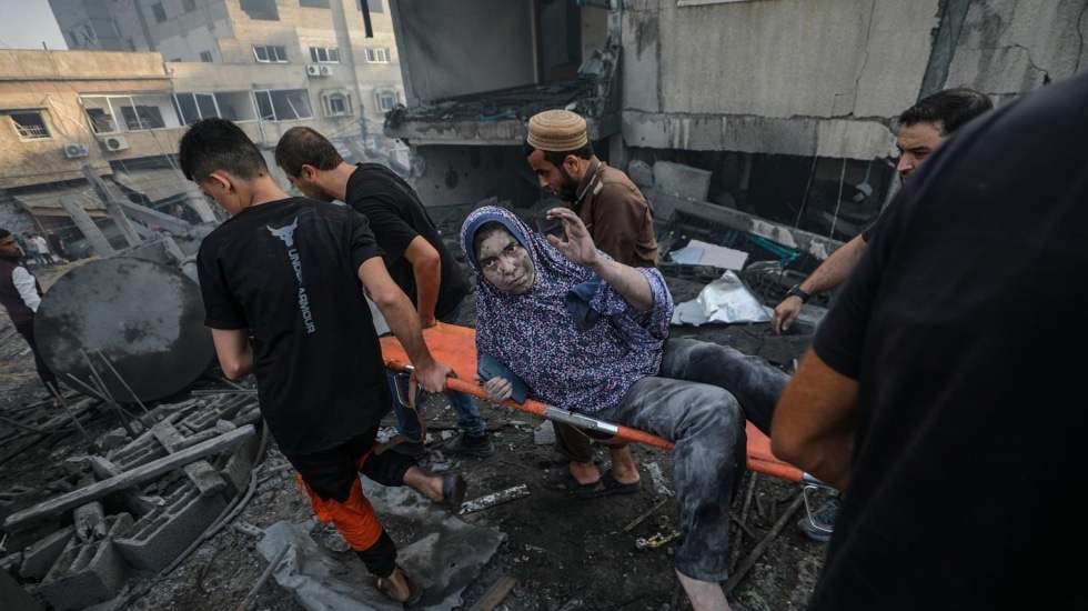 Una mujer es auxiliado en un edificio golpeado por un ataque aéreo israelí en la ciudad de Gaza.