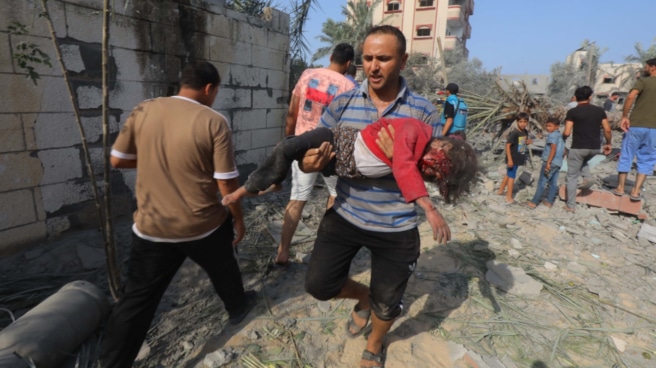Un hombre lleva en brazos a un niño herido tras un bombardeo israelí este domingo sobre Deir al-Balah.
