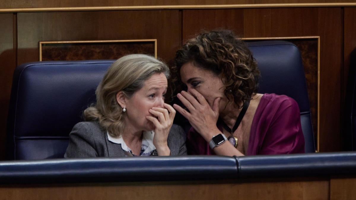 La vicepresidenta primera del Gobierno y ministra de Asuntos Económicos, Nadia Calviño, y la ministra de Hacienda, María Jesús Montero, conversan durante una sesión plenaria en el Congreso de los Diputados.