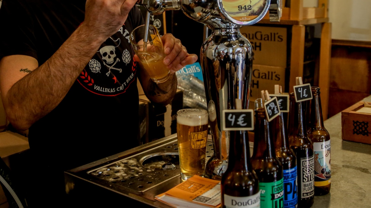 Un camarero tira una cerveza artesanal en uno de los bares de Lavapiés, en Madrid.