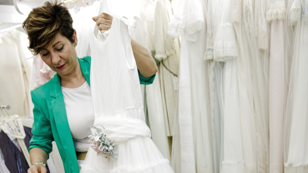 Una dependienta enseña un vestido en la tienda de Leganés en la que trabaja.