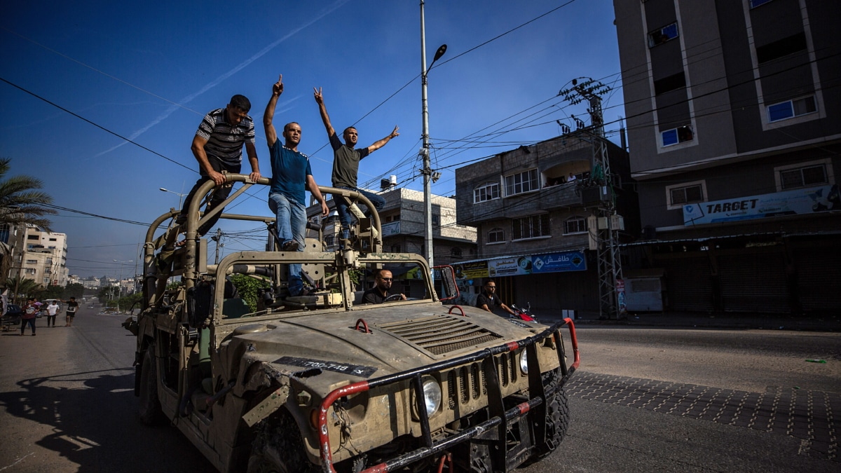 Los palestinos viajan en un jeep militar israelí por las calles del norte de la Franja de Gaza durante el asalto a los asentamientos israelíes