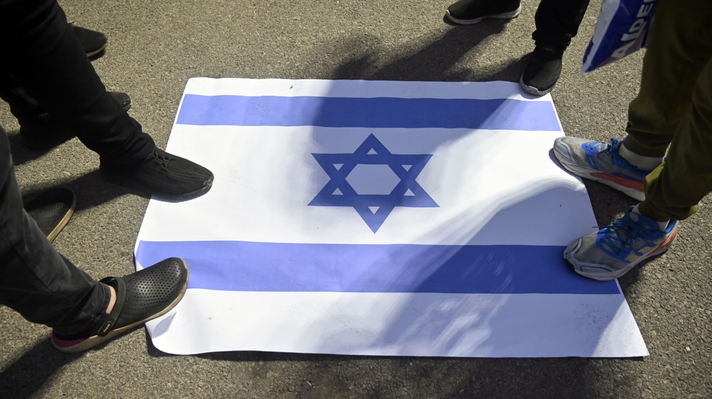 Militantes de Hizbulá pisotean la bandera israelí en una manifestación en Beirut.