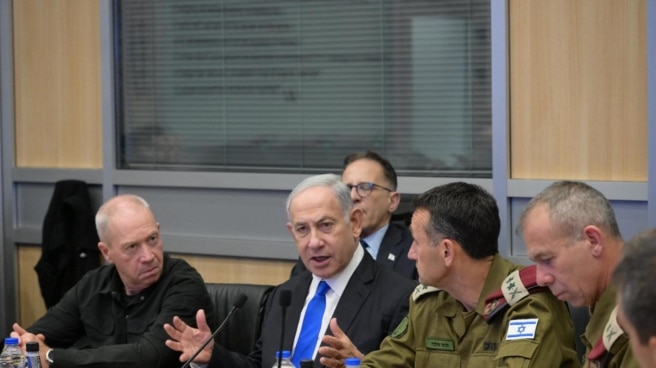 El primer ministro de Israel Benjamin Netanyahu (C) y el minitro de Defensa Yoav Gallant (IZ)