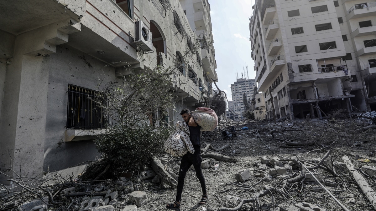 Un palestino porta sus pertenencias en mitad de una Gaza devastada