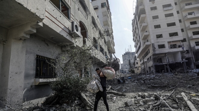 Un palestino porta sus pertenencias en mitad de una Gaza devastada Un palestino porta sus pertenencias en mitad de una Gaza devastada