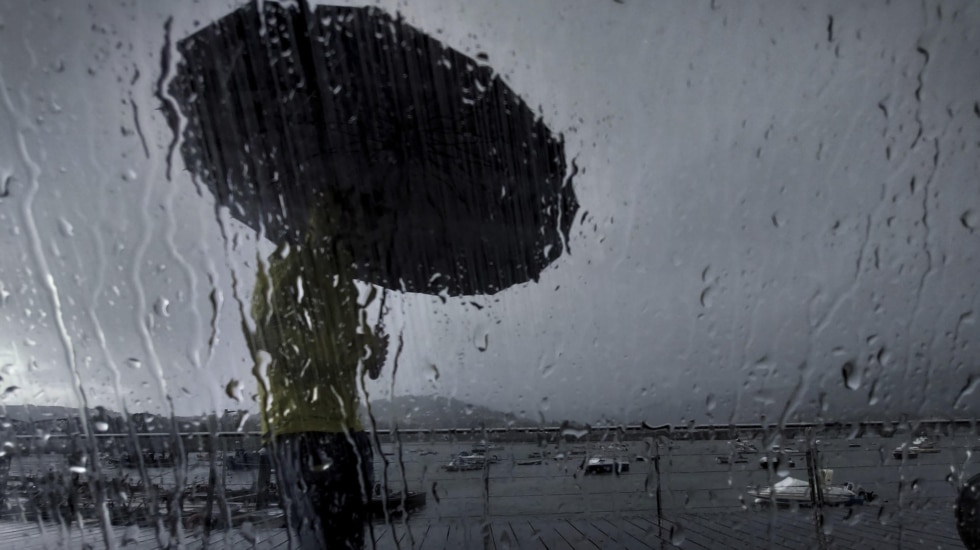 Un hombre con paraguas camina este lunes por el puerto de Pontedeume, en una jornada marcada nuevamente por las lluvias