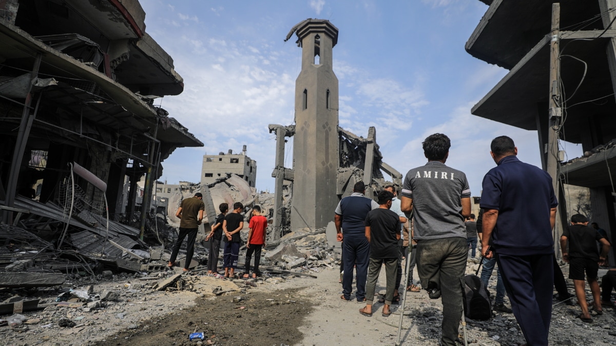 Los palestinos se reúnen entre los escombros de una zona destruida después de los ataques aéreos israelíes en la ciudad de Gaza, el 9 de octubre de 2023.