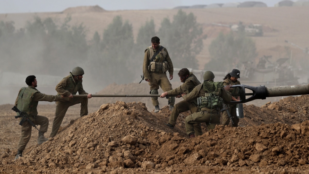 - Soldados de artillería israelíes limpian un cañón en una zona a lo largo de la frontera con Gaza, sur de Israel