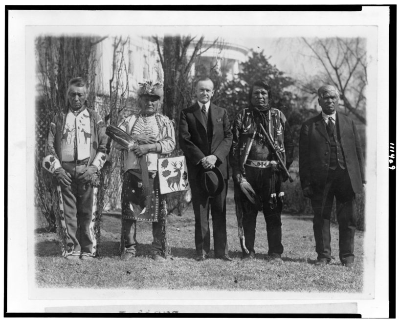 El presidente Calvin Coolidge posa con nativos Osage, cerca del jardín sur de la Casa Blanca.