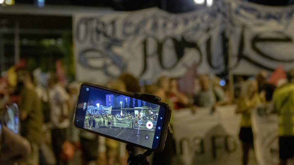 Participante con cámara en la manifestación contra la cumbre en Granada.