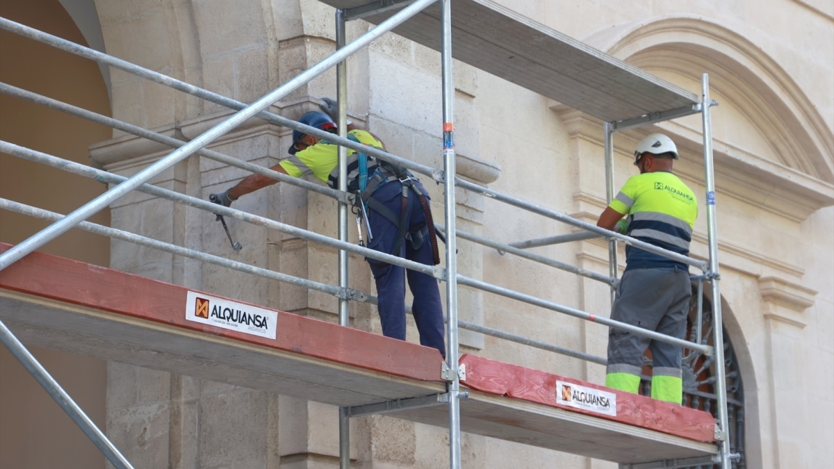 Operarios trabajando en el montaje de los andamios para la restauración de la fachada central del Ayuntamiento de Sevilla.